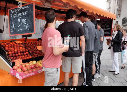 Les personnes achetant des fruits en été, pour un marché plein air stall en Allemagne. Banque D'Images