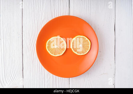 Tranches de citron sur ronde horizontale de la plaque orange Banque D'Images