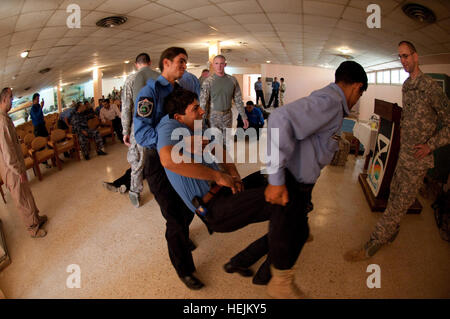 Policiers iraquiens apprennent à évacuer des blessés à partir de la scène d'un accident au cours de la deuxième journée de deux jours de cours de base Gareautrain est enseigné dans Village touristique de Habbaniyah, l'Iraq, le 6 octobre, par des infirmiers de l'armée américaine avec 1er bataillon du 504e Parachute Infantry Regiment, 82nd Airborne Division (Conseiller et aider Brigade). L'Armée de techniciens médicaux adaptés aux techniques de combat gareautrain aux besoins et aux ressources de la propriété intellectuelle. Apprendre la police iraquienne en sauvetage de Paratrooper Medecins 212522 Banque D'Images