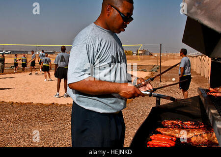 US Army CAMP TAJI, 53448 Iraq-Sgt. 1re classe Thelton Cobb, de Little Rock, Ark., le sous-officier responsable de la logistique avec le Siège et l'Administration centrale, l'entreprise prépare des côtes et des hot-dogs pour le déjeuner du Banque D'Images