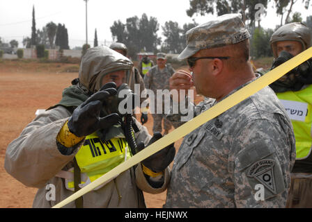 Un soldat de l'avant du commandement israélien Accueil 945e d'armes nucléaires, biologiques et chimiques, du bataillon, du district de Dand, traite de la zone chaude et froide avec les procédures de l'Armée Le sergent de la Garde nationale de l'Ohio. 1re classe David Nickerson 21 octobre 2009, au cours d'une manifestation de la décontamination des procédures. Nickerson est le sous-officier responsable de la Garde nationale de l'Ohio, chimiques, biologiques, radiologiques, nucléaires et explosifs à haut rendement de la Force de réaction de l'amélioré, l'équipe qui compte neuf membres en Israël pour l'exercice de formation conjoints Cobra 10 Juniper, impliquant la Force de défense israélienne et Accueil/pers Banque D'Images