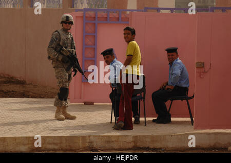 Le sergent de l'armée américaine. Michael Gallagher, attaché au blanc, Peloton, batterie Alpha 1-77 Field Artillery, assure la sécurité des membres de l'Équipe de reconstruction provinciale de Wasit pour la cérémonie d'inauguration de l'Open Education College, avec des membres de la police irakienne à Kut, l'Iraq, le 24 octobre. Le collège a été reconstruit avec l'aide de la PRT de Wasit. Aux États-Unis, les forces iraquiennes participent à l'ouverture du collège 217232 Banque D'Images