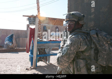 Le Sgt. Brandon Ford, originaire de Fresno, Californie, soldat de la police militaire, 3e Stryker Brigade Combat Team, 2e Division d'infanterie, regards retour à sa chef d'équipe pour obtenir de l'orientation après l'ont reçu le feu de l'ennemi dans le village de Shar-e-Tiefort au Centre National d'entraînement, Fort Irwin Aug 14. Les soldats de la police militaire sont la formation de s'adapter à de nouvelles situations et de procéder à des patrouilles à pied et l'interaction avec la population locale. Les chasseurs de rechercher leurs partenaires afghans 444743 Banque D'Images