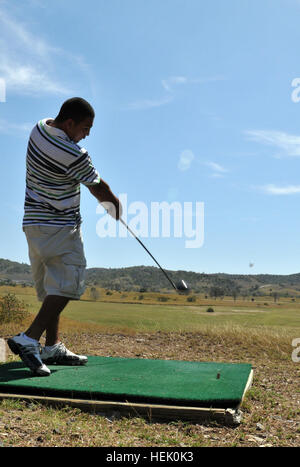 GUANTANAMO BAY, Cuba - Aviation Marine Officier mécanicien de 2e classe Juan Sealey, déployée à Guantanamo de la Force interarmées avec la Marine Expeditionary Guard bataillon, lance sa balle de golf de la pièce en t sur 17 trous, sur sa journée au moral, du bien-être et Loisirs Golf de Yatera, danger "Latéral" le 1er mars 2010. L'NEGB fournit une partie de la force de garde à l'intérieur de la Force opérationnelle de détention de Guantanamo. Guantanamo la foi mène sûr, humain, juridique et transparent le soin et la garde des détenus, y compris ceux qui ont été condamnés par une commission militaire et ceux commandés libéré par un tribunal. Le J Banque D'Images