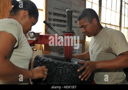 GUANTANAMO BAY, Cuba - Le Sergent de l'armée. La Sierra de Bibbs (à gauche) et de l'Armée de la CPS. Yusef A. Abdul, avec le 525e Bataillon de la Police militaire, mettre de nouveaux pneus sur des jantes à la Force opérationnelle de Guantanamo 525e Bataillon de la Police militaire Motor Pool, 17 mars 2010. Guantanamo la foi mène sûr, humain, juridique et transparent le soin et la garde des détenus, y compris ceux qui ont été condamnés par une commission militaire et ceux commandés libéré par un tribunal. La foi mène des activités de collecte, d'analyse et de diffusion pour la protection des détenus et du personnel travaillant dans les installations de Guantanamo de la foi et à l'appui de la guerre Banque D'Images