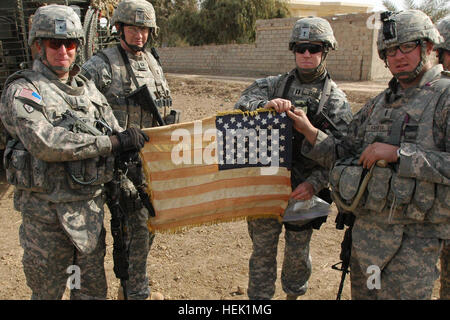 TAJI, Iraq - de gauche à droite : San Bernardino, Californie, natif Lieutenant-colonel Thomas H. Mackey, commandant, du 2e Escadron, 14e Régiment de cavalerie, 2e Stryker Brigade Combat Team, "Warrior", 25e Division d'infanterie, Leavenworth, Kansas, le Capitaine Nathaniel Crow indigènes, commandant des troupes, B, 2e Escadron, 14e Régiment de cavalerie, 2nd Stryker Brigade Combat Team, "Warrior", 25e Division d'infanterie, Green Bay, Wisconsin (Etats-Unis), le capitaine Joseph Dumas indigènes et autochtones Rochester, N.Y., 1er lieutenant Michael Kaness, afficher le drapeau de combat Hoe lors d'une patrouille le 22 janvier. Ils détiennent le drapeau à l'envers pour symboliser la façon dont les soldats portent Banque D'Images