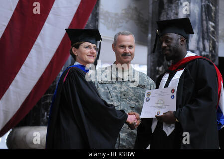 Diplômé (à droite) reçoit un Embry-Riddle Aeronautical University Maîtrise en sciences de l'éducation sciences sécurité certificat centre de Brig. Le général Donald J. Currier (centre), commandant de la 49e Brigade de police militaire, et Carolyn L. Baker (à gauche), chef de programmes de formation continue, Bureau du secrétaire de la Défense. Les membres du Service pendant un déploiement 283580 diplômés Banque D'Images