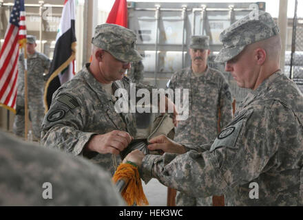 Commandant de la 203e Bataillon de la Police militaire Le Lieutenant-colonel Charles Buxton (droite) et commande le Sgt. Maj Perry Hooper, la 203e, le sergent-major de commandement du bataillon de cas, tandis que les couleurs 49e commandant de brigade MP Brig. Le général Donald J. Currier (centre) supervise la 203e et 206e Bataillon MP MP Entreprise fin de mision cérémonie, Base d'opérations d'urgence, à Bassorah, Irak, le 6 juin. La 203e est le premier bataillon MP de redéployer sans avoir un remplaçant. 203e Bataillon MP mission se termine dans le sud de l'Iraq 291963 Banque D'Images