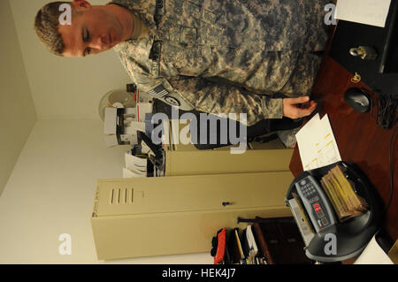 Lieutenant de l'armée américaine Bradley Steinle, d'Erie, dans l'Illinois, de Bravo 126e Détachement de la gestion financière, 3e Bataillon des troupes spéciales, 3e brigade de maintien en puissance, 103e Commandement de soutien expéditionnaire vérifie la quantité d'argent dans une pile d'argent comptant de l'argent avec une machine à base d'opérations dans l'est du delta de l'Iraq, le 10 juillet. Des soldats américains avec 126FA distribué payer US occasionnels des soldats qui n'ont pas accès à des devises fortes en Iraq dans le cadre de l'opération Iraqi Freedom. (U.S. Photo de l'armée par la CPS. Charles M. Willingham) Gestion financière 301161 Delta FOB Banque D'Images