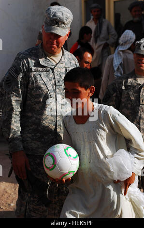 Le colonel Daniel E. Williams, 4e brigade, commandant de l'aviation de combat regarde un villageois afghans s'enfuit avec un ballon de soccer. Au cours de la visite, le 4ème de l'eau de la cabine et des fournitures scolaires. 328164 Villages Banque D'Images