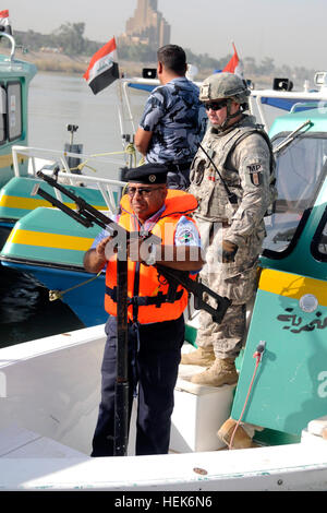 Un officier de police irakien avec la patrouille de la rivière Bagdad (à gauche) prépare son arme sur la proue de son bateau de patrouille, le 17 octobre, avant une mission conjointe sur le Tigre, avec des soldats de la 94e Compagnie de Police Militaire, 1er Conseiller et aider Brigade, 3e Division d'infanterie, United States Division - Centre. (U.S. Photo de l'armée par le sergent. Jennifer Menger) Bagdad River Patrol assure la sécurité sur le tigre pour les citoyens irakiens 333310 Banque D'Images