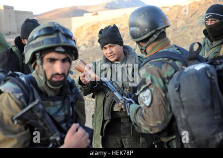 Un membre de la Police nationale afghane parle de sa compétence à de commandos afghans 2e Kandak de commando, lors d'une patrouille dans le village de Barakat pendant une opération de bouclage et de ratissage dans la province de Ghazni, Novembre 6, 2010. (U.S. Photo de l'armée par le Sgt. Justin P. Morelli / Relâché) Fonctionnement silencieux poignard, l'opération Enduring Freedom 345263 Banque D'Images