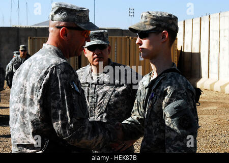 Le Sgt commande. Le major Rodney R. Lewis (à gauche), sergent-major de commandement de la 2e Brigade d'aider et de conseiller, 1re Division d'infanterie, Division des États-Unis - Centre, félicite la CPS. Cody Boettcher (à droite), un ingénieur avec 228e compagnie du génie, 1e Bataillon, 63e régiment de blindés, 2e Aab, 1er Inf. Div., et un Reedsville, Wisconsin (Etats-Unis), les autochtones, lors d'une cérémonie au camp de la liberté, de l'Iraq. Boettcher a reçu ses blessures alors qu'il était dans un véhicule lorsqu'une tourelle du canonnier explosivement formées sur projectile à proximité. USD-C soldat décerné Purple Heart 352770 Banque D'Images