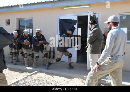 Un entrepreneur civil à partir de la Xe Services, (à droite), observe que les agents de police des frontières afghanes compensation pratique un prix à la frontière d'ABP Centre à Spin Boldak, Afghanistan. Les soldats de l'Armée américaine affecté à la formation de l'OTAN a établi un partenariat avec Mission-Afghanistan entrepreneurs civils de charger des armes d'ABP, notions de prix de dédouanement, l'établissement de points de contrôle routier et la conduite de véhicule et des patrouilles à pied. Le programme de sept semaines est conçu pour renforcer la formation pour la police des frontières pour lutter contre l'activité des insurgés le long de 1 200 milles de l'Afghanistan avec le Pakistan boundary. Les soldats américains, les entrepreneurs civils moi Banque D'Images