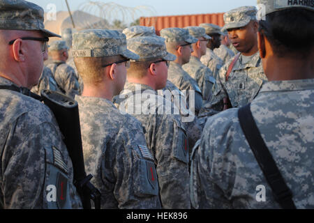 Avec les soldats de la 94e Compagnie de Police militaire, des troupes spéciales, 2e Bataillon de la Brigade d'aider et de conseiller, 1re Division d'infanterie, United States Division - Béquille centrale en formation, le 31 décembre, alors que le sergent de la commande. Le major Verne Washington (deuxième à droite), sergent-major de commandement de STB, 2e AAB et un natif de la ville de New York, place une 1ère Division d'infanterie du manchon d'épaule - 44624 - ex-service en temps de guerre, plus connus sous le nom de patch de combat, sur leur épaule droite au camp de la liberté, de l'Iraq. (U.S. Photo de l'armée par le Sgt. Joseph Weichel) EUR-C des troupes spéciales des soldats du bataillon recevoir les correctifs 356576 combat Banque D'Images