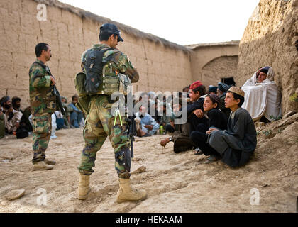 Un commando de l'Afghanistan, avec l'Armée nationale afghane par le 3e Commando Le Kandak, parle des enfants afghans lors d'une opération de nettoyage du village dans le nord du district de Khakrez, 25 mai 2011, la province de Kandahar, Afghanistan. Les Commandos, appuyé par U.S. Navy SEALs avec Special Operations Task Force - Au sud, ont été rejoints par des membres de la Police nationale afghane et chef de police de district de Ghorak, Alam Guhl. (U.S. Photo de l'armée par le Sgt. Daniel P. secoua)(1992). Présence du gouvernement étend au cours de l'opération de compensation de Kandahar 408440 Banque D'Images