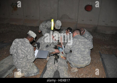 Le Cpl. Amire Jennings, une sous-direction des ressources humaines avec le 1er Bataillon du 63e régiment de blindés, 2e Brigade d'aider et de conseiller, 1re Division d'infanterie, United States Division - Centre et d'un canton, N.J., indigène, consigne les renseignements personnels d'une "victime" dans le cadre de responsabilisation du personnel au cours d'un exercice d'entraînement d'un grand nombre de blessés, le 16 juin 2011 au camp de la liberté, de l'Iraq. Mooneyham Capitaine Dave (extrême gauche), aumônier de l'unité pour le 1er Bn. 63e régiment de blindés., originaire de Colombie-Britannique, S. Voiture., rassure le soldat blessé que les médecins travaillent à garder le patient en vie et bien au cours de la c Banque D'Images