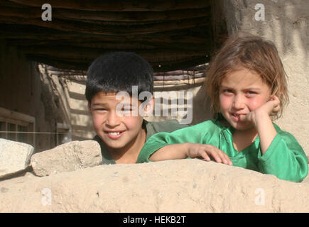 Deux enfants afghans de regarder derrière le mur d'un des soldats de l'armée américaine comme khalat de la société C, 1er Bataillon, 133e Régiment d'infanterie, Task Force Ironman, l'équipe de combat de la 2e Brigade d'infanterie, 34e division de montagne, TF Red Bulls et soldats de l'Armée nationale afghane, du 2e Peloton, 1er Kandak, 201e Corps d'infanterie de l'ANA, patrouille via Khanda, Village province de Laghman, Afghanistan, le 18 juin. Kalagush soldats patrouillent route IED connu 422998 Banque D'Images