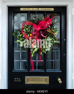 Une couronne de Noël festive est suspendu à la porte d'une maison de près de la cathédrale de Salisbury, Wiltshire, Royaume-Uni Banque D'Images