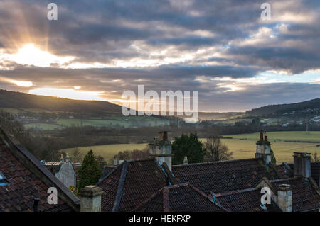 Batheaston, Somerset, Royaume-Uni. 22 décembre 2016. Météo France : Le soleil se lève pour briser la couverture de nuages afin de brûler la brume sur les toits du village. Au sol sont Bathampton les pâtures - le site proposé pour un projet controversé d'un parking Park and Ride Crédit : régime Richard Wayman/Alamy Live News Banque D'Images