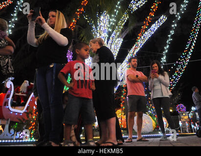 Winter Park, Floride, USA. 22 Décembre, 2016. Les gens apprécient un affichage de lumières de Noël à la maison de la famille de Johannessen Winter Park, Floride le 22 décembre 2016. L'attraction, qui est aussi le thème de la retraite d'été du père Noël et établit une facture d'électricité de 500 $ par mois, comprend 250 000 feux, un traîneau en bois faits à la main, une douzaine de bounce house, jeux gonflables, maison de la musique, et un bateau pour Saint Nick flottant près du lac de la famille dock. Eric Johannessen, un entrepreneur local, a installé l'écran depuis 2010, de grandes foules de dessin tous les soirs. Crédit : Paul Hennessy/Alamy Live News Banque D'Images