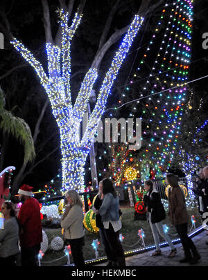 Winter Park, Floride, USA. 22 Décembre, 2016. Les gens apprécient un affichage de lumières de Noël à la maison de la famille de Johannessen Winter Park, Floride le 22 décembre 2016. L'attraction, qui est aussi le thème de la retraite d'été du père Noël et établit une facture d'électricité de 500 $ par mois, comprend 250 000 feux, un traîneau en bois faits à la main, une douzaine de bounce house, jeux gonflables, maison de la musique, et un bateau pour Saint Nick flottant près du lac de la famille dock. Eric Johannessen, un entrepreneur local, a installé l'écran depuis 2010, de grandes foules de dessin tous les soirs. Crédit : Paul Hennessy/Alamy Live News Banque D'Images