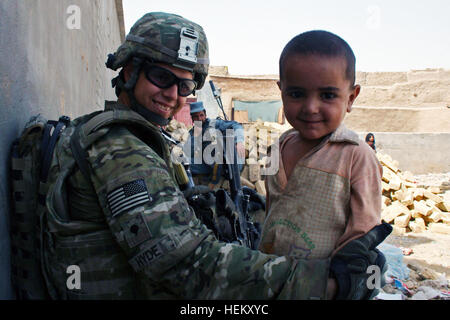 La VILLE DE KANDAHAR, Afghanistan (sept. 30) - de la CPS. Jody Hyde, un policier militaire avec la 58e Compagnie de Police Militaire jointe à l'équipe de combat de la 2e Brigade, 4e Division d'infanterie, se lie d'amitié avec un jeune garçon afghan au cours d'une patrouille de la circulation communautaire le 30 septembre. Des soldats du 58e Compagnie MP et leurs partenaires de la police en uniforme afghane station de police auxiliaire 16 sont allés dans leur communauté pour se connecter avec les gens. (U.S. Photo de l'armée par la CPS. New York, 2e avril BCT, 4e Inf. Div., PAO) cœur tendre 110930-A-QO451-002 Banque D'Images