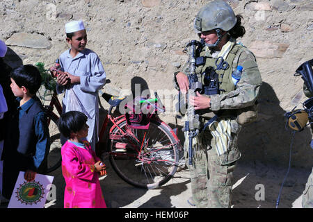 La province de Wardak, Afghanistan - membre de l'équipe de traitement des femmes, affecté à la Force opérationnelle d'opérations spéciales - est, parle d'une petite fille au cours d'une patrouille, Sayed Abad district, le 6 novembre. Les forces spéciales de l'Armée nationale afghane et de la coalition des forces d'opérations spéciales bonbons distribués, l'art et des fournitures scolaires, et manivelle radio pour les enfants et les familles. (U.S. Photo de l'armée par le Sgt. Lizette Hart, 19e Détachement des affaires publiques) Présence en patrouille Sayed Abad 485347 Banque D'Images