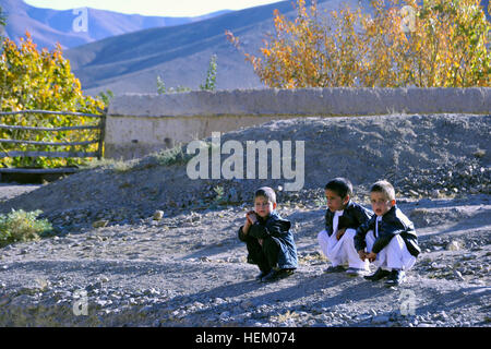 La province de Wardak, Afghanistan - Trois jeunes garçons attendre patiemment les forces spéciales de l'Armée nationale afghane et de la coalition des forces d'opérations spéciales de distribuer des sucettes au cours d'une patrouille, Sayed Abad district, le 6 novembre. Les forces distribué des bonbons, de l'art et des fournitures scolaires, et les radios à manivelle les enfants et les familles. (U.S. Photo de l'armée par le Sgt. Lizette Hart, 19e Détachement des affaires publiques) Présence en patrouille Sayed Abad 485356 Banque D'Images