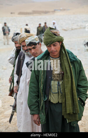 La police locale afghane à attendre les candidats reçoivent des vêtements pour temps froid dans Kajran, Daykundi province, Afghanistan, le 25 novembre 2011. L'alpage de candidats ont reçu tout le matériel nécessaire pour rester efficace au combat au cours de la saison d'hiver. ALP froid question 111125-A-NC985-003 Banque D'Images