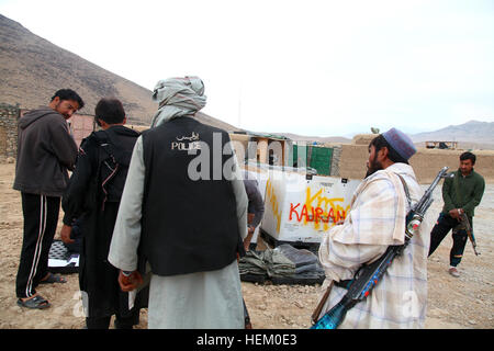 La police locale afghane à attendre les candidats reçoivent des vêtements pour temps froid dans Kajran, Daykundi province, Afghanistan, le 25 novembre 2011. L'alpage de candidats ont reçu tout le matériel nécessaire pour rester efficace au combat au cours de la saison d'hiver. ALP froid question 111125-A-NC985-040 Banque D'Images