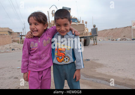 Deux enfants irakiens s'embrassent et ricaner devant un véhicule blindé dans un village au nord de Bagdad, le 17 novembre. Avec la mission de l'armée américaine couvrant les huit ans en Irak, la vue de soldats et de matériel militaire est courant pour des jeunes irakiens. Les fantassins affecté à la compagnie C du 2e bataillon du 325e Régiment d'infanterie aéroportée,, 2e Brigade, 82e Division aéroportée, s'est rendu au village de Camp Taji pour recueillir des informations concernant les récentes attaques dans la région. La 2e Brigade est la dernière brigade dans Bagdad et continue de collaborer avec les forces de sécurité iraquiennes pour faciliter la Banque D'Images