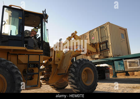 La CPS. Gabriel Ramirez, un spécialiste des munitions attribués à une entreprise, 407e Bataillon de soutien de la Brigade, 2e Brigade, 82e Division aéroportée, charge un conteneur sur un camion à plateau dirigé au Koweït sur la base aérienne d'Al-Asad, Iraq, 3 déc. 407e avec les parachutistes sont BSB déménagement de l'équipement essentiel à l'extérieur de l'Iraq jours avant le chiffre d'affaires du camp de l'armée iraquienne. Ramirez est originaire de San Diego (Californie) se préparent à quitter les parachutistes Al-Asad 495555 Banque D'Images