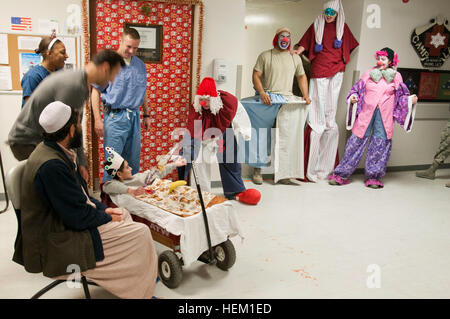 Najibullah, 10, (en wagon) répond à quelques "clowns" au cours de l'hôpital Craig Joint-Theater le défilé du Nouvel An, 1 janvier, son 164e jour en vertu de l'hôpital de garde. Najibullah a été gravement blessé dans l'estomac le 20 juillet dans la province de Ghazni. Le personnel de l'hôpital a mené le défilé à travers les couloirs de l'hôpital, l'Najibullah agissant comme Grand maréchal. Craig Joint-Theater la plus longue de l'hôpital le personnel résident inspire 120101-A-S930-011 Banque D'Images