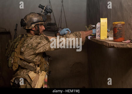 Un membre d'une force de frappe par les Afghans un composé des recherches pendant une opération de Nadir Shah Kot district, province de Khost, en Afghanistan, le 16 janvier 2012. Au cours de l'opération un leader Haqqani a été capturé. Ce chef formé et dirigé des combattants insurgés de mener des attaques à la bombe en bordure de route. Les forces afghanes mènent des raids nocturnes 120116-A-SO723-026 Banque D'Images