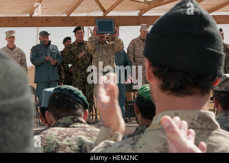 Un agent de police avec la Police nationale afghane de l'ordre civil affiche son certificat d'alphabétisation à la foule lors de la remise des diplômes à l'Académie de soutien conjoint au sud-ouest, le 16 février, le Camp Sapadalure, Afghanistan. Vingt-deux étudiants ont obtenus un diplôme dans deux cours différents en matière d'alphabétisation et d'armes de petit calibre instructeur. Outil d'éducation pour la transition à l'ÉVALUATIONS CONJOINTES 120216-A-AC860-343 Banque D'Images