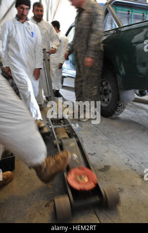 La province de Paktya, Afghanistan - Les membres de la police en uniforme afghane et de la police frontalière afghane manoeuvrer un cric lors d'une maintenance préventive, vérifie et classe les services menées par le peloton de maintenance de l'Administration centrale et de l'Administration centrale, l'entreprise 4ème Airborne Brigade Combat Team, 25e Division d'infanterie, Groupe de travail sur la base d'opération avancée Spartan Gardez, 19 février. (U.S. Photo de l'armée par la CPS. Ken cicatrice, 7e MPAD) AUP, ABP apprendre la réparation des véhicules, à Gardez camaraderie 120219-A-S930-003 Banque D'Images