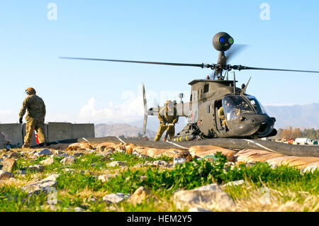 La province de Nangarhar, Afghanistan - l'armée américaine la FPC. James Warner, de Cameron, N.C., se prépare à un carburant OH-58 Kiowa Warrior alors que la CPS. Sean Shuttleworth, de Columbia, S.C., mans l'extincteur sur la base d'opération avancée Fenty. Les deux soldats sont spécialistes pétroliers affectés à la Force Sabre, 82e Brigade d'aviation de combat. (U.S. Photo de l'armée par le Sgt. 1ère classe Eric Pahon, Groupe de travail des affaires publiques de Poséidon) Flickr - l'armée américaine - Kiowa Warrior refuel Banque D'Images