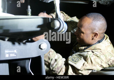 La CPS. Ricardo Anderson, de Montego Bay, Jamaïque fonctionne sur un système de rotor principal d'hélicoptère Apache tard dans la nuit, sur la base d'opérations Foward Fenty. Task Force Sabre, 82e Brigade d'aviation de combat, est responsable de l'espace aérien au-dessus de la province de Nangarhar, à proximité de la frontière avec le Pakistan- une opération de 24 heures qui maintient la mécanique Apache comme Anderson travailler à toute heure du jour et de la nuit. Tard dans la nuit, 541768 Banque D'Images