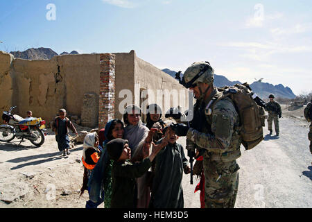 ARGHANDAB, Afghanistan - Le Sgt. Juan Almaguer, infirmier de la Compagnie A, 1er Bataillon, 67e régiment de blindés, 2e Brigade Combat Team, 4e Division d'infanterie, les mains des bonbons aux enfants afghans lors d'une patrouille à l'extérieur des portes de poste de combat Jannat, le 9 mars. Almaguer, originaire de San Bernardino, en Californie, et son peloton ont été rejoindre la communauté, réunion avec la police locale afghane et à distribuer les bonbons, qui les enfants locaux voir le chocolat. (U.S. Photo de l'armée par le Sgt. New York, 2e avril BCT, 4e Inf. Div., PAO) Chocolats 120309-A-QO451-001 Banque D'Images