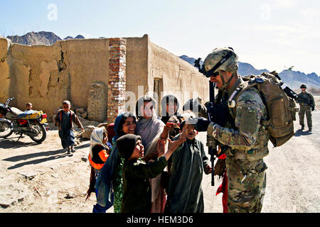 Le Sgt. Juan Almaguer, infirmier de la Compagnie A, 1er Bataillon, 67e régiment de blindés, 2e Brigade Combat Team, 4e Division d'infanterie, les mains des bonbons aux enfants afghans lors d'une patrouille à l'extérieur des portes de poste de combat Jannat, le 9 mars. Almaguer, originaire de San Bernardino, en Californie, et son peloton ont été rejoindre la communauté, réunion avec la police locale afghane et à distribuer les bonbons, qui les enfants locaux voir le chocolat. Flickr - l'armée américaine - appel de bonbons Banque D'Images