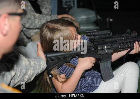 Un soldat du 4e Bataillon, 6e Régiment d'infanterie, 4e Brigade Combat Team, 1re Division blindée, prend en charge une jeune fille alors qu'elle une carabine M4 au niveau de la mission du formateur Compétences 2000 sur le Fort Bliss, Texas, le 20 mars 2013. La jeune fille faisait partie d'un groupe de garçons et filles de troupes de scouts locaux apportés par 4-6 dans le cadre du programme Partenaires en éducation. (Photo par le Sgt. Robert Larson, 4e Brigade Combat Team) Affaires publiques n° 278 reçoit la formation de troupes 130320-A-EB339-252 Banque D'Images