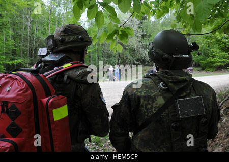 Les soldats allemands du 371e Bataillon d'observer l'arrivée de blessés qui ont été touché par un engin explosif improvisé lors d'une équipe de liaison et de mentorat opérationnel (ELMO) de l'entraînement à la préparation interarmées multinationale Centre à Hohenfels, Allemagne, le 5 mai 2012. XXIII de l'ELMO de la police et de l'Équipe de liaison et de mentorat opérationnel (ELMO) VII la formation sont conçus pour préparer les équipes de déploiement en Afghanistan avec la capacité de former, de conseiller et de permettre aux Forces nationales de sécurité de la Force dans des domaines tels que la contre-insurrection, combattre, consultatif et de travail permettant aux opérations de soutien. (U.S. Photo de l'armée S Banque D'Images