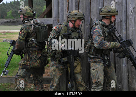 Les soldats allemands du 371e Bataillon d'infanterie se préparent à rechercher un bâtiment lors d'une équipe de liaison et de mentorat opérationnel (ELMO) de l'entraînement à la préparation interarmées multinationale Centre à Hohenfels, Allemagne, le 5 mai 2012. XXIII de l'ELMO de la police et de l'Équipe de liaison et de mentorat opérationnel (ELMO) VII la formation sont conçus pour préparer les équipes de déploiement en Afghanistan avec la capacité de former, de conseiller et de permettre aux Forces nationales de sécurité de la Force dans des domaines tels que la contre-insurrection, combattre, consultatif et de travail permettant aux opérations de soutien. (U.S. Photo de l'armée par le Sgt. Evanoff Kirk/non publié) opérationnel de l'OTAN Banque D'Images