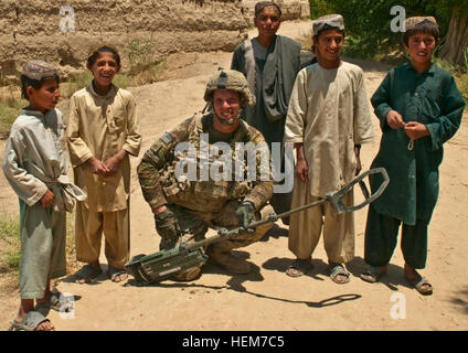 Le s.. Rogne, un soldat avec 3e peloton, Compagnie Bravo, 1er Bataillon du 23e Régiment d'infanterie, pose avec des enfants du village dans le sud de l'Afghanistan pendant une patrouille à pied où ils ont découvert, désarmés et ont fait exploser deux plaque de pression des dispositifs explosifs de circonstance à quelques 100 mètres sur la route à partir de certaines des maisons d'enfants le 20 juin 2012. Patrouiller avec EOD une étape à la fois 120619-A-VB107-045 Banque D'Images