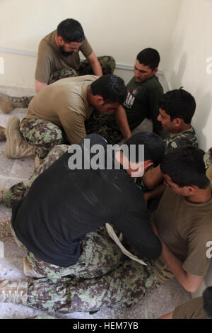 Les soldats de l'Armée nationale afghane, pratiquer l'utilisation d'un engin garrots au cours d'un combat gareautrain cours sur l'avant poste Narizah Khowst, province, l'Afghanistan, le 9 juillet 2012. C'était la première classe de combat gareautrain enseigné par un soldat de l'ANA sur Narizah. (U.S. Photo de l'armée par le Sgt. Kimberly Trumbull) ANA classe CLS 120709-A-PO167-040 Banque D'Images