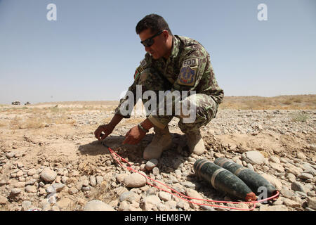 Un instructeur de l'Armée nationale afghane, affecté à la 4e Kandak, 203e Corps canadien démontrent la bonne méthode de pose d'un engin explosif improvisé pour une détonation contrôlée pendant un exercice de formation de bataille le 30 juillet 2012, à la base d'opérations avancée Shank, province de Logar, en Afghanistan. (U.S. Photo de l'armée par le Sgt. Austin Berner/libéré) d'entraînement en Afghanistan 120730-A-BZ540-025 Banque D'Images