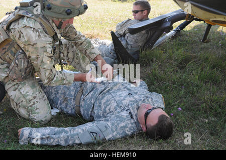 Un soldat de l'armée géorgienne de la Compagnie Bravo du 32e Bataillon d'infanterie rend l'aide médicale aux blessés de l'armée américaine théoriquement le Capitaine Aaron Adams, de l'état de préparation interarmées multinationale Centre (JMRC) au cours d'un exercice de répétition de mission (MRE) à l'JMRC en Hohenfels, Allemagne, 14 août 2012. Emr sont conçus pour préparer les unités pour le déploiement sur le théâtre des opérations en Afghanistan pour mener des contre-insurrection, la stabilité, et des opérations de transport à l'appui de la Force internationale d'assistance à la sécurité. (U.S. Photo de l'armée par la CPS. Fredrick J. Willis Jr./libérés) 12e et 32e lumière géorgienne Infantr Banque D'Images