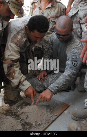 Le s.. Jeremy Buef, originaire de Cincinnati, Ohio, et d'une équipe leader avec la Compagnie Bravo, 1er Bataillon, 14e d'infanterie, 2e Brigade Combat Team, 25e Division d'infanterie, aide un soldat de la Brigade de protection régional kurde avec correctement identifier un point d'un modèle de terrain au cours de la navigation terrestre, de formation à l'administration centrale à KRGB Laylan, près de Kirkouk, Irak, le 11 août. Renforcer la confiance dans les soldats Hawaii Partenaires 311589 Banque D'Images