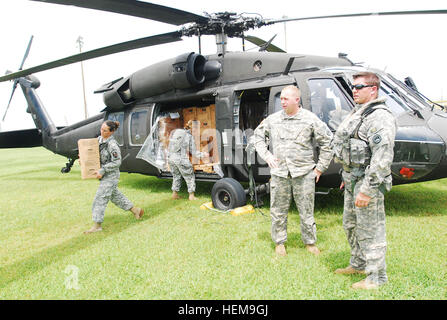 Des soldats américains avec le 1020th Ingénieur vertical, l'entreprise 527e bataillon du génie, de la Garde nationale de la Louisiane (LANG) recueillir les repas, prêt à manger et de l'eau d'un UH-60 Black Hawk pour distribution au centre d'une opération d'urgence à Grand Isle, en Louisiane, le 31 août 2012. LANG avait plus de 8 000 soldats et aviateurs, prête à soutenir les habitants de la région et les collectivités locales et les autorités de l'état à l'appui de l'ouragan Isaac. Isaac développé comme une tempête tropicale sur l'ouest de l'Océan Atlantique le 21 août 2012, touchant à Puerto Rico, la République dominicaine, Haïti et Cuba avant qu'il est descendu comme un hur Banque D'Images